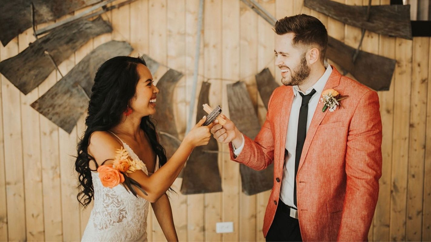 a couple toasting with churros on their wedding day