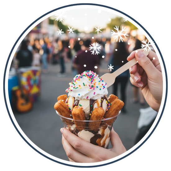 A person holding a gourmet churro sundae with colorful toppings, with the blurred background of a lively outdoor community festival.