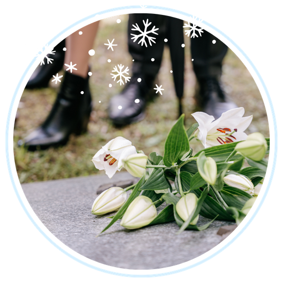 Flowers on funeral grave with people standing behind Flowers on funeral grave with people standing behind
