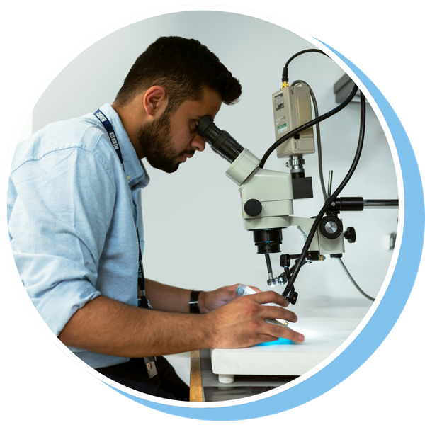 research assistant looking through microscope