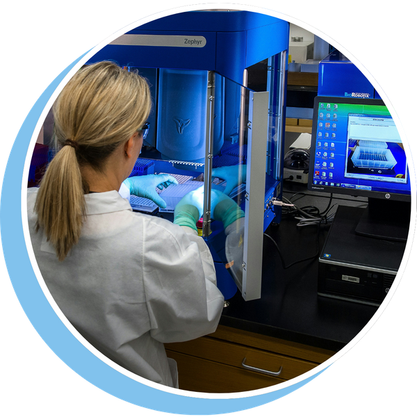 A person in a lab coat examining an object 