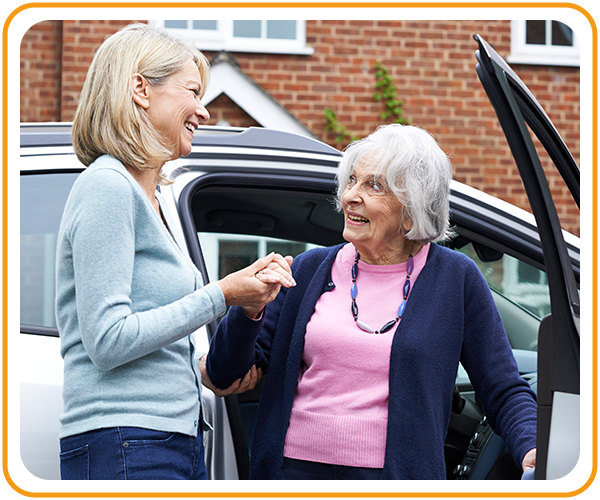 caregiver helping patient out of car