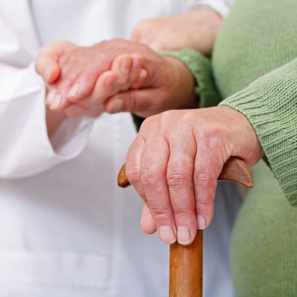 close up of older mans hand holding cane