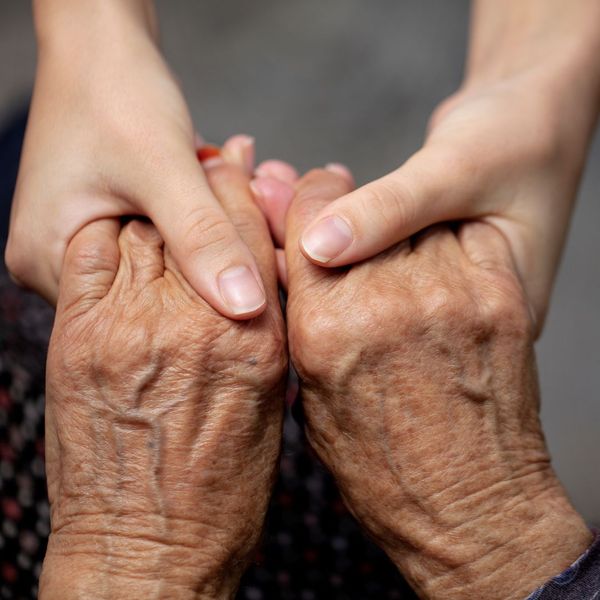 close up of younger person holding older persons hands