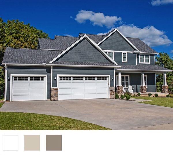 Dark blue house with white garage doors