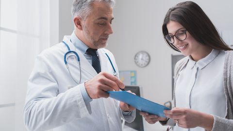 A doctor reviewing medical documents with a patient