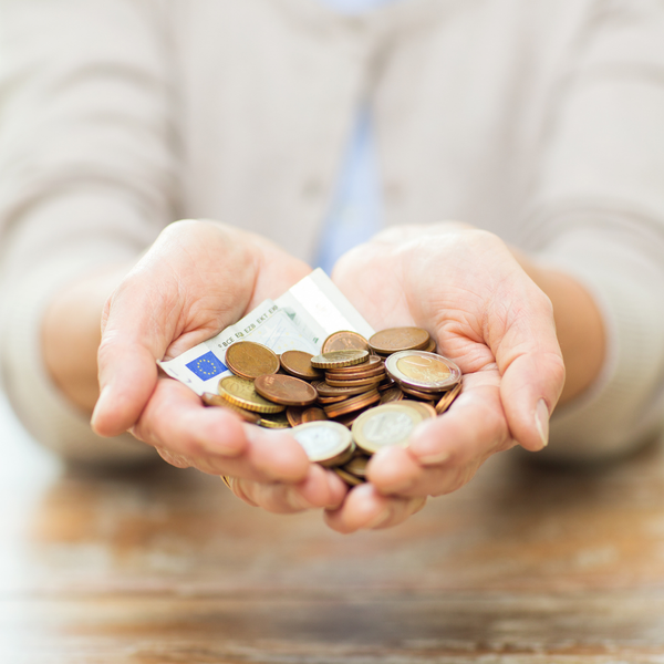 A woman holding cash and coins.