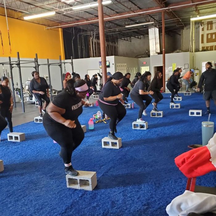 An image of women standing on cinder blocks during a fitness class.