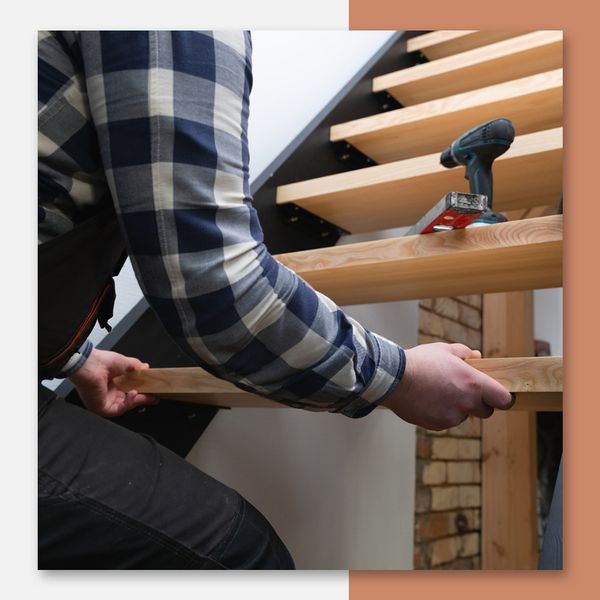A flooring contractor installing a wood staircase