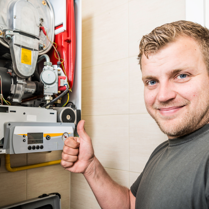 man smiling with thumbs up in front of a furnace