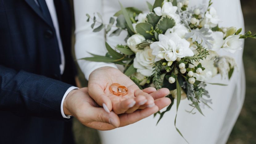 bride and groom holding rings
