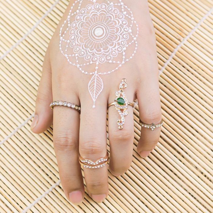 A bride's hand with henna and gold and silver rings