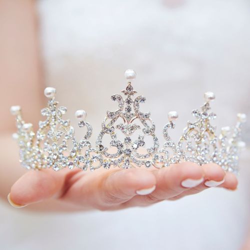 a woman holding a modern tiara