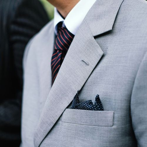 a polka dot navy pocket square paired with a light grey suit