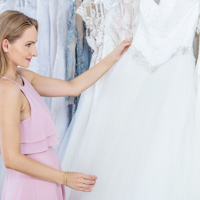 woman looking at wedding dress woman looking at wedding dress