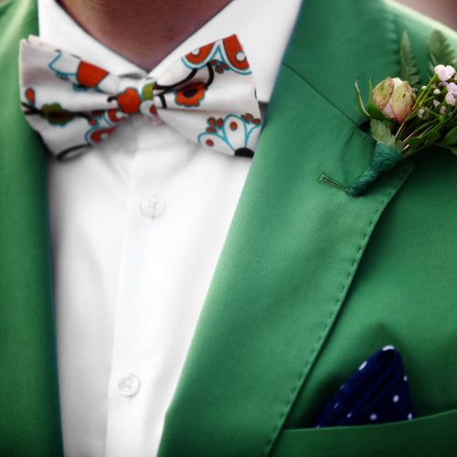 a bold floral bowtie paired with a green suit