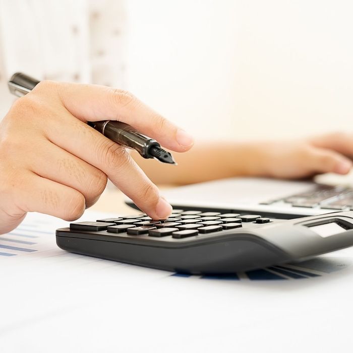 person using a calculator to budget