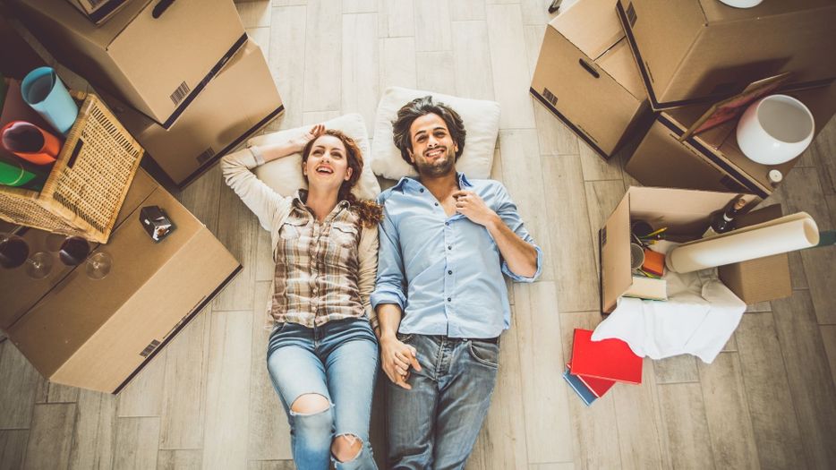 people in their new apartment with boxes to unpack