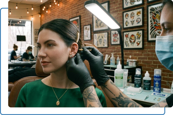 women getting ear pierced