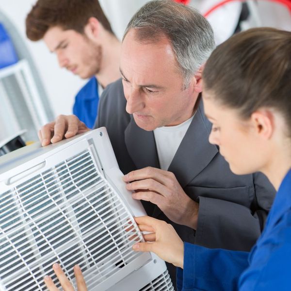 Technicians inspecting an HVAC air filter.