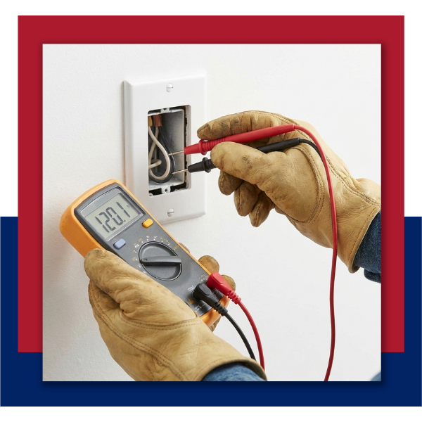 Close-up of an electrician testing wall voltage with a professional multimeter tool.