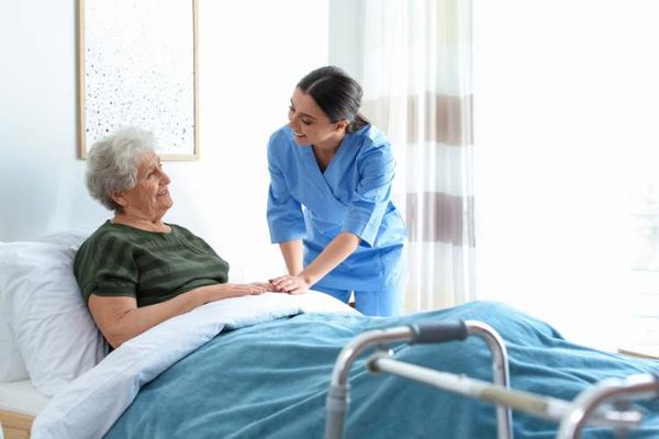 nurse comforting woman in bed