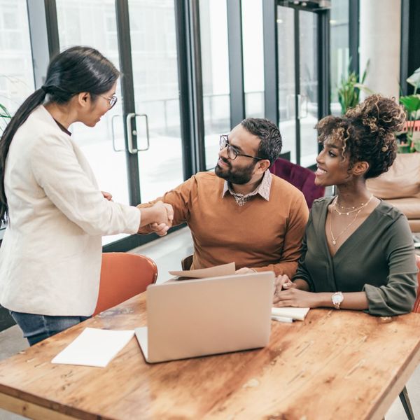 couple shaking life insurance agent's hand