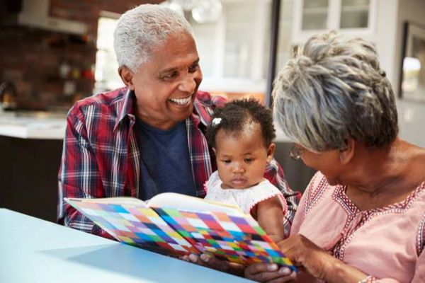 grandparents reading to their grand child