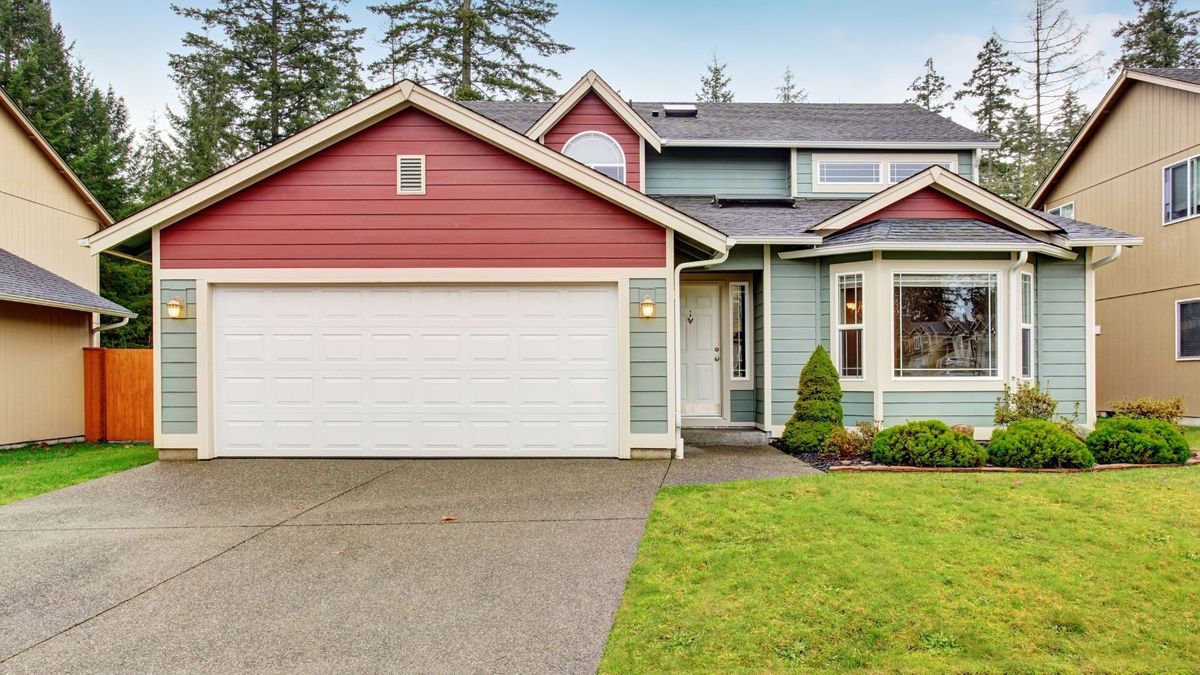 A red and blue home with a large white garage door