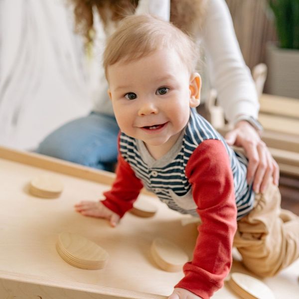 baby climbing on toy