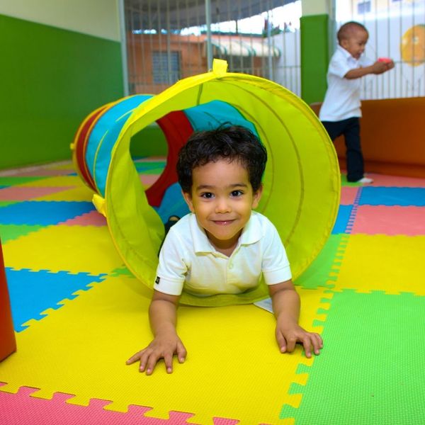 little boy playing in a tunnel