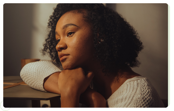 sad/pensive woman resting chin on arm