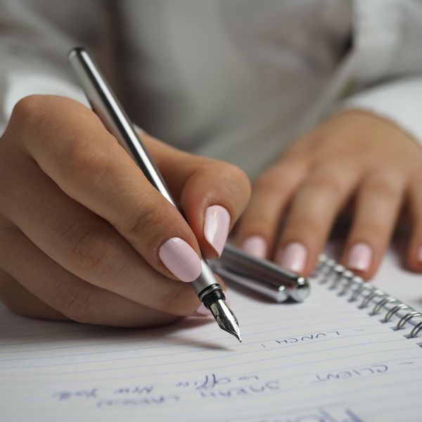 person writing in notebook