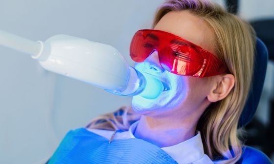woman with UV light whitening on her teeth