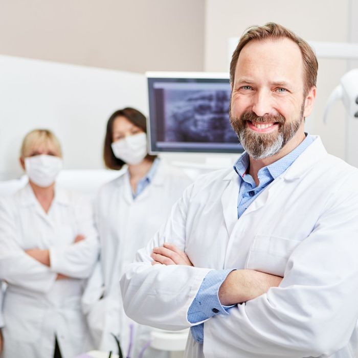 a happy dentist and their team