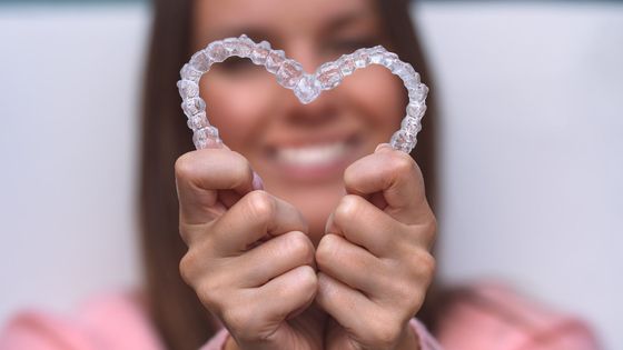 person holding set of invisalign aligners in shape of heart