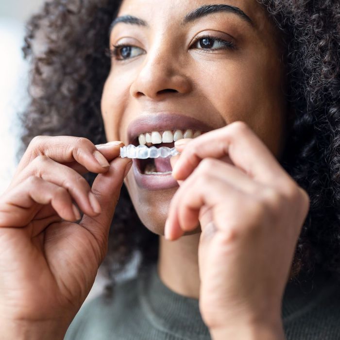 person inserting invisalign