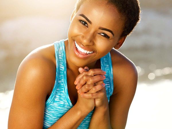 Portrait of happy black fitness woman laughing outside