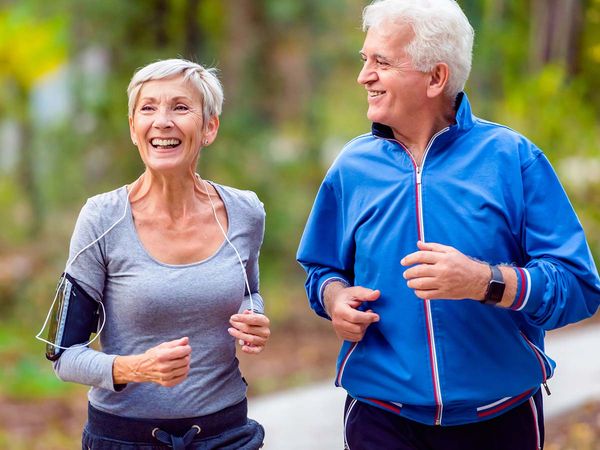 Smiling senior couple jogging in the park. Smiling senior active couple walking, jogging and talking in the park.