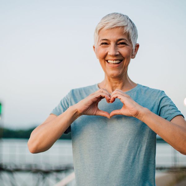 woman holding hands in heart symbol