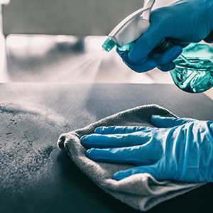 Person spraying cleaner on surface