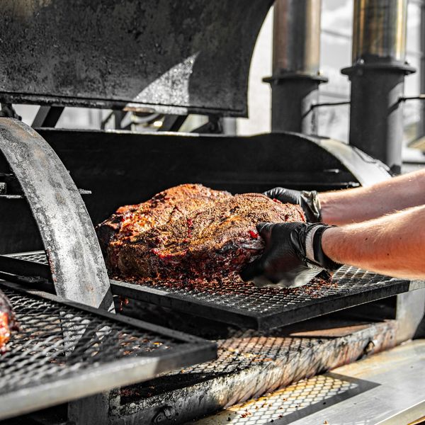 home bbq-er putting meat in smoker home bbq-er putting meat in smoker
