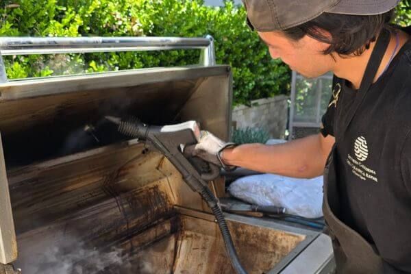 man cleaning a grill