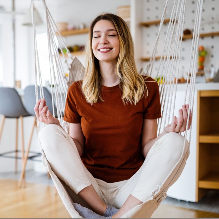 woman happy and at peace in a swing inside home