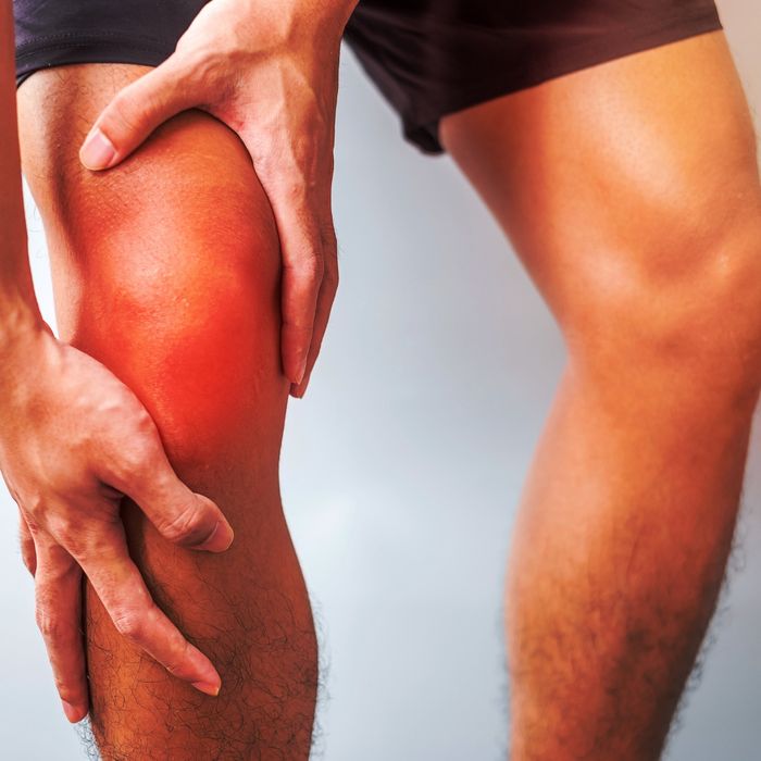 man holding inflamed knee