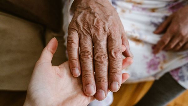 holding an elderly persons hand showing difference in skin holding an elderly persons hand showing difference in skin