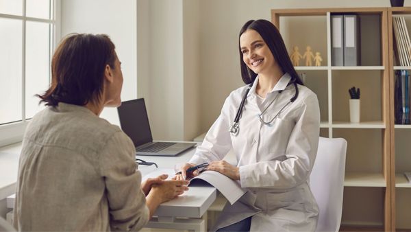 A female medical professional conducting a consultation for spider vein therapy in Denver