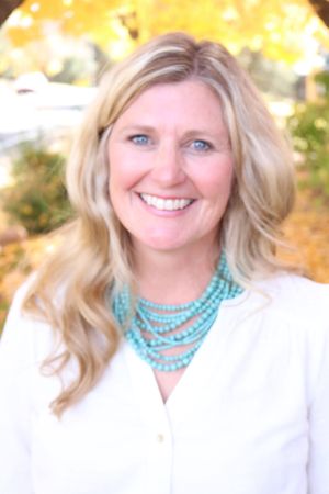 Theresa Kegerreis, founder of PurePoint Wellness, smiling outdoors in a professional portrait. Featured in Voyage Denver magazine for her holistic healing and AcuDetox work in Broomfield, CO. This image represents the face and mission of PurePoint Wellness - personalized, compassionate holistic health care. Theresa Kegerreis founder of PurePoint Wellness smiling outdoors featured in Voyage Denver magazine