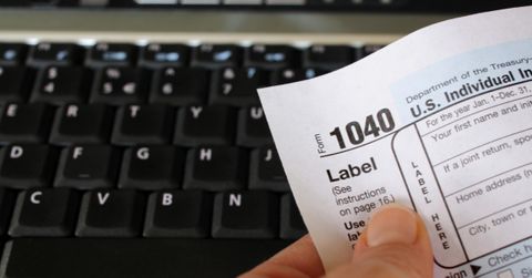 A person holding a 1040 tax form