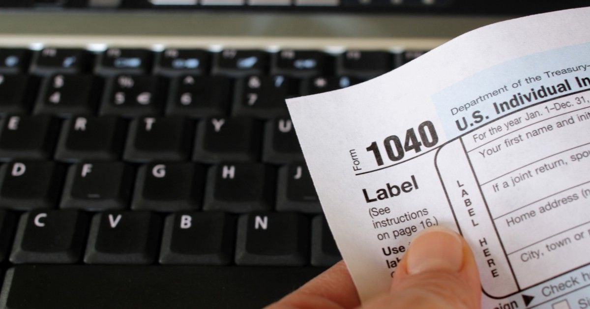 A person holding a 1040 tax form